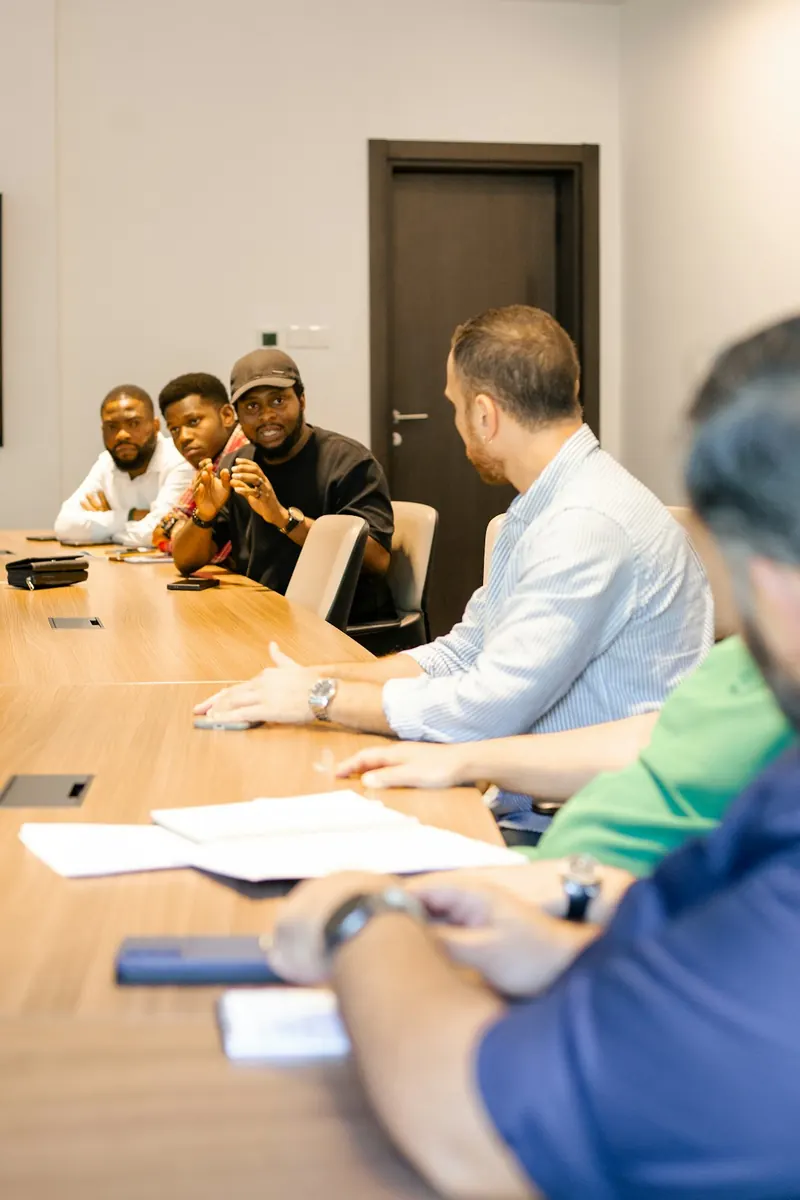 Un responsable en discussion avec son équipe autour d'une table de réunion